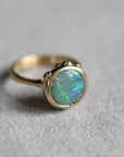 Gold ring with an opal stone on a gray surface