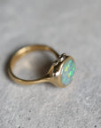 Gold ring with an opal stone on a gray background