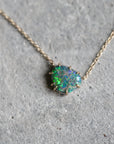 Opal necklace on a gray concrete surface