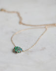 Necklace with a green opal pendant on a light background