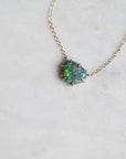Necklace with a green opal pendant on a light gray background