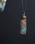 Opal pendant necklace on a dark background