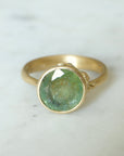 mossy green montana sapphire set in a gold ring with barnacles
