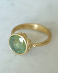 mossy green montana sapphire set in a gold ring with barnacles