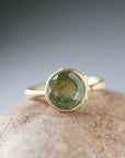 mossy green montana sapphire set in a gold ring with barnacles