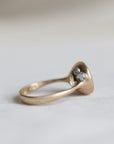 Gold ring with a diamond in barnacles on a light gray background