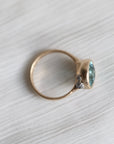 Gold ring with a blue gemstone on a textured white surface