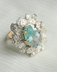 A ring with a wreath of silver roses around a pale blue tourmaline stone