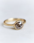 A 1.38ct diamond ring. The diamond has a chestnut hue and is set in 18k gold with an 18k gold band. The setting is encrusted with 14k gold barnacles. The ring is viewed off center and is set on a white background.