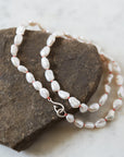 Baroque white freshwater pearl Ruthie B. necklace with coral-hued silk and silver clasp by Hannah Blount