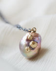 detail of pink freshwater baroque pearl necklace with gold barnacles and black oxidized silver chain by hannah blount jewelry