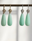 Two pairs of teardrop shaped chrysoprase earrings with rose accents, one pair is 14k yellow gold and the other is in bright sterling silver.