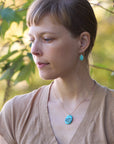 Woman wearing turquoise earrings and necklace outdoors