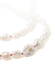 Baroque white freshwater pearl necklace with coral-hued silk and gold clasp by Hannah Blount