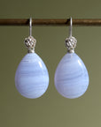 swirly pale blue lace agate teardrops hang beneath silver ear wires featuring little silver roses on them