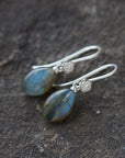 flashing with blue, grey labradorite cones hang beneath silver ear wires and silver roses.
