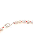 detail of necklace made of multi sized white freshwater baroque pearls strung on coral silk with silver barnacles and fish hook clasp