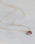 Necklace with a purple gemstone pendant on a light background