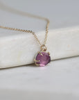Necklace with a purple gemstone pendant on a white surface