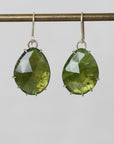 Green teardrop earrings on a gray background