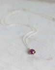 Necklace with a purple gemstone pendant on a light background