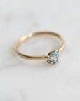 0.4ct pale blue Montana sapphire vanity ring set in 14k yellow gold with four asymmetrical prongs.