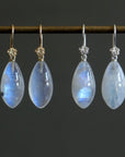 two pairs of moonstone drop earrings. One pair has silver ear wires with roses and one pair has gold ear wires and roses.