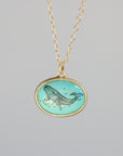 Necklace with a pendant featuring a whale design on a gray background