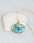 Necklace with a turquoise pendant featuring a whale design on a light gray background