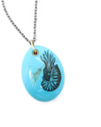 kingman turquoise pendant with inked illustration of a nautilus on oxidized silver chain with gold details