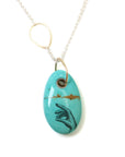 kingman turquoise bead with hand scrimshaw in ink. Pendant necklace with bright silver chain with gold egg link.