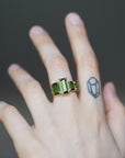 four stone green tourmaline and gold ring on person