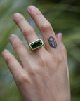green tourmaline rectangle cut stone ring set in gold with barnacles- on person