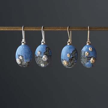 two pairs of mottled blue common opal earrings, one pair with silver barnacles and ear wires and one pair with gold barnacles and ear wires