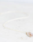 dendritic agate necklace laying on white surface