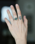 Large aquamarine ring with barnacles on hand with tattoo
