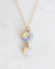 Two stone opal pendant set in yellow gold with a yellow gold chain against a neutral background.