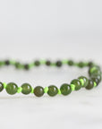 Green beaded necklace on a white background
