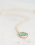 Emerald necklace laying on marble with barnacle details