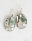 Moss agate earrings on marble background