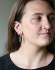 Woman wearing elongated stone earrings