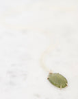 Green gemstone necklace on marble background