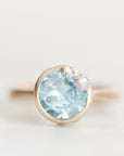 Light blue gemstone ring set in gold bezel accented with platinum barnacles set with diamonds.