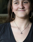 Woman wearing purple necklace pendant