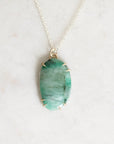 Green stone necklace with gold prongs close up