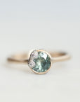 Green sapphire ring in gold bezel setting with platinum barnacles set with tiny diamonds