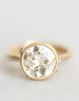 Diamond set in 18k yellow gold bezel against a white background