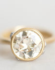 Diamond set in 18k yellow gold bezel against a white background