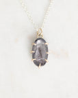 Necklace with a dark stone pendant on a light gray background