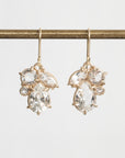 Gold earrings with clear gemstones on a white background
